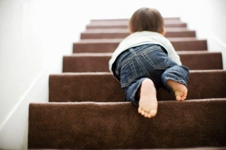 A baby crawling on the stairs